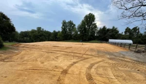 An excavation contractor is prepping a dirt field for a horse race.