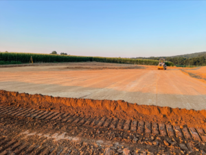 A construction site with a bulldozer performing earthwork in the background.