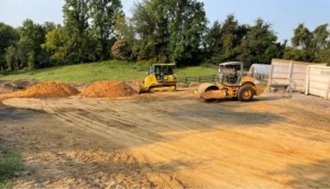 An earthwork contractor is utilizing a bulldozer for site development on a dirt road.