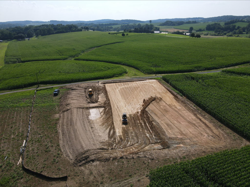 An aerial view of an excavation contractor at a construction site in a field.