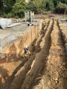 An earthwork contractor is excavating a trench for stormwater management.